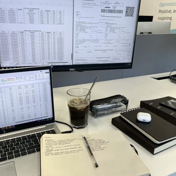 Laptop, monitors, and notebooks at a desk